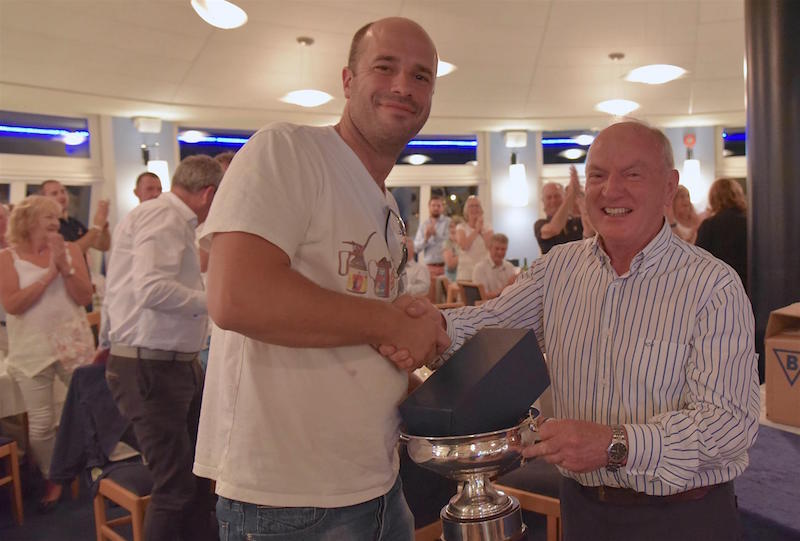 Deilginis helm Luke Massey is presented the Howth 17 trophy by Class Captain (and Handicap winner) Tom Houlihan. 